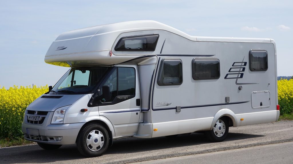 Puesta a punto camper en primavera: guía antes de salir Autocaravana junto a un campo en flor, lista para la primera escapada de primavera
